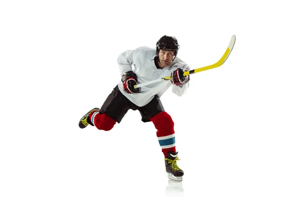 Joven jugador de hockey masculino con el palo en la pista de hielo y fondo blanco — Foto de Stock