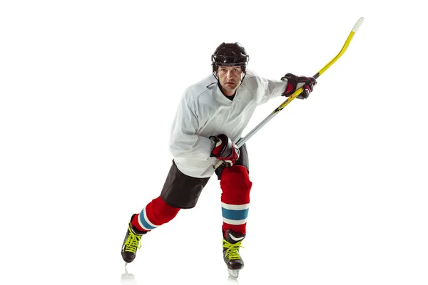 Mladý mužský hokejista s holí na ledovém hřišti a bílém pozadí — Stock fotografie