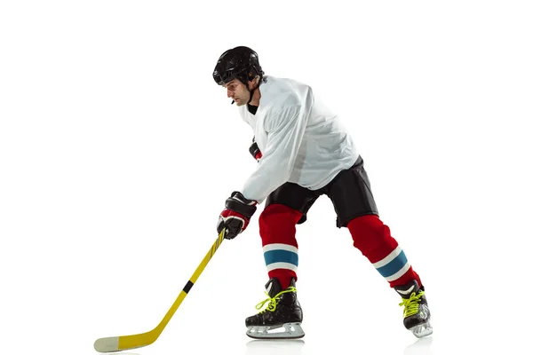 Mladý mužský hokejista s holí na ledovém hřišti a bílém pozadí — Stock fotografie