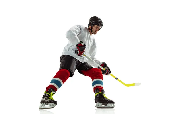 Jeune joueur de hockey masculin avec le bâton sur le terrain de glace et fond blanc — Photo