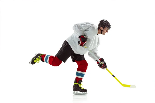 Joven jugador de hockey masculino con el palo en la pista de hielo y fondo blanco — Foto de Stock