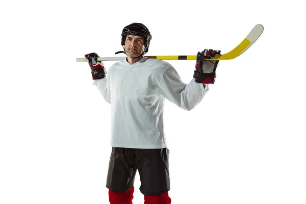 Young male hockey player with the stick on ice court and white background — Stock Photo, Image