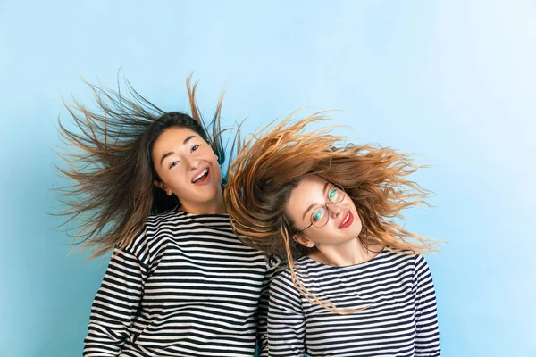 Junge emotionale Frauen auf blauem Hintergrund — Stockfoto