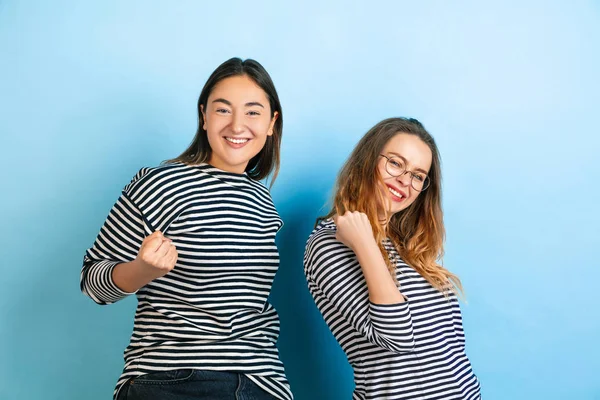Jovens mulheres emocionais no fundo azul gradiente — Fotografia de Stock