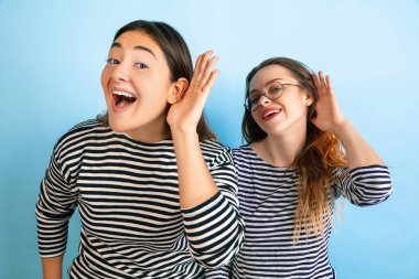 Değişken mavi arka planda genç duygusal kadınlar