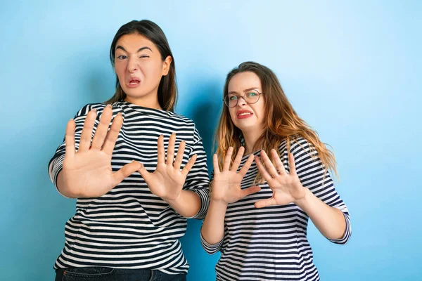 Jovens mulheres emocionais no fundo azul gradiente — Fotografia de Stock