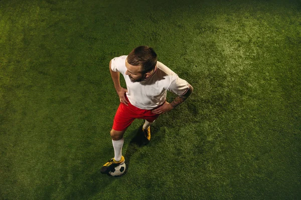 Вид зверху кавказького футболіста або футболіста на зеленому тлі трави — стокове фото