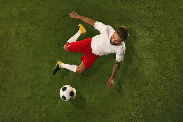 Vista superior do futebol caucasiano ou jogador de futebol no fundo verde da grama — Fotografia de Stock