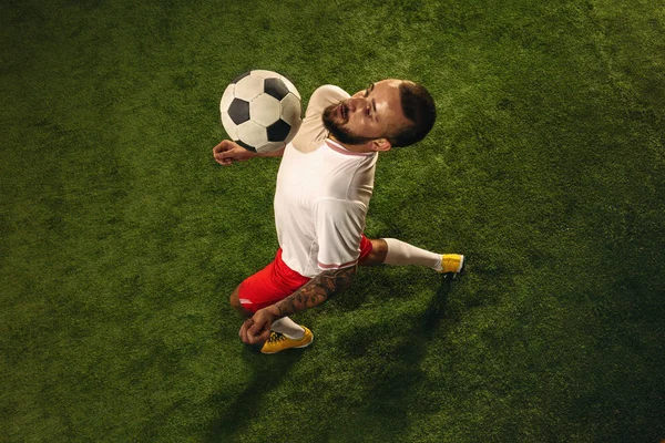 Vista superior do futebol caucasiano ou jogador de futebol no fundo verde da grama — Fotografia de Stock