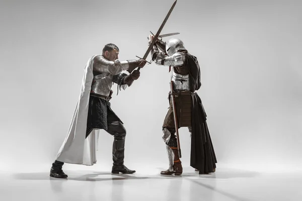 Хоробрі броньовані лицарі борються ізольовані на білому фоні студії — стокове фото