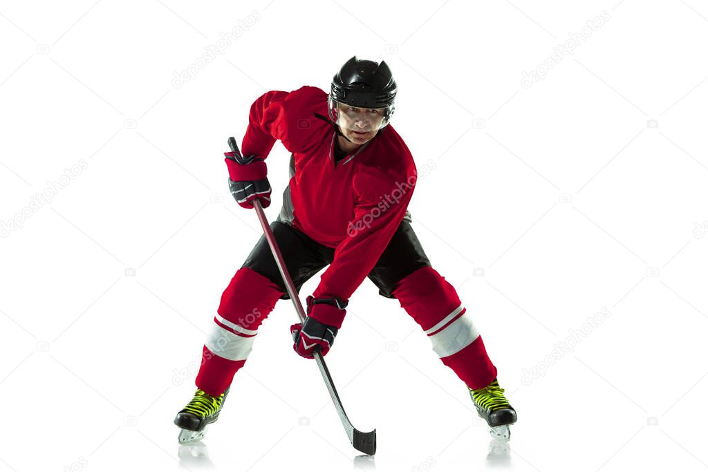 Male hockey player with the stick on ice court and white background