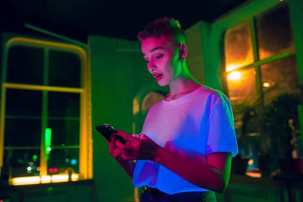 Neon ışıklı iç mekan içinde yakışıklı genç bir kadının sinematik portresi. — Stok fotoğraf