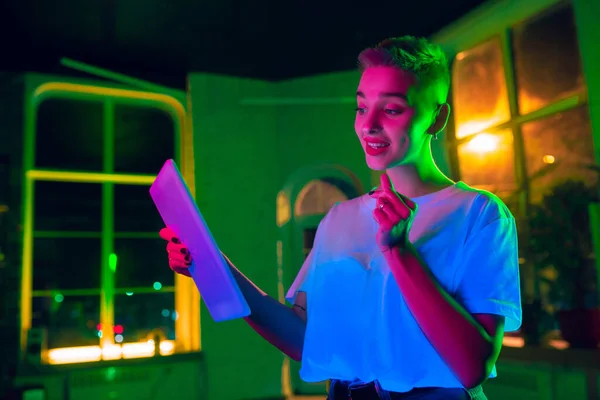 Fényképes portré jóképű fiatal nő neon kivilágított belső — Stock Fotó