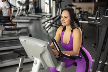 Spor salonunda sıkı çalışan bayan sporcu. Fitness ve sağlıklı yaşam konsepti.