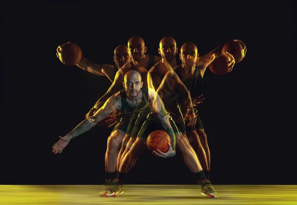 Giovane giocatore di basket formazione su sfondo scuro studio in neon, luce stroboscopica — Foto Stock