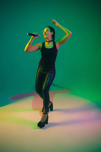 Portrait de chanteuse caucasienne isolé sur fond de studio vert au néon — Photo