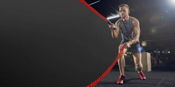 Joven atleta sano haciendo ejercicio en el gimnasio con cuerdas, volante con copyspace — Foto de Stock