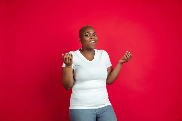 African-american young womans portrait on red background — Stok fotoğraf