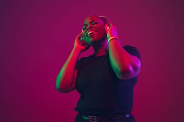African-american young womans portrait on purple pink background