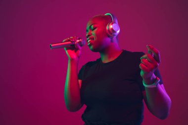 African-american young womans portrait on purple pink background