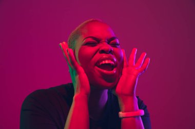 African-american young womans portrait on purple pink background