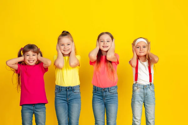 Happy children playing and having fun together on yellow studio background — Φωτογραφία Αρχείου