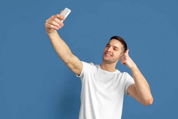 Caucasien jeunes hommes portrait sur fond bleu studio — Photo