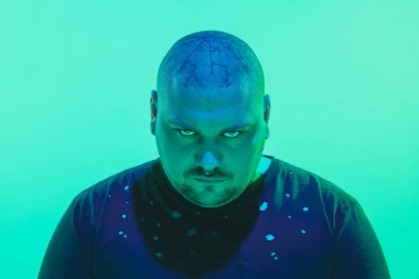 Portrait of a guy with colorful neon light on green background