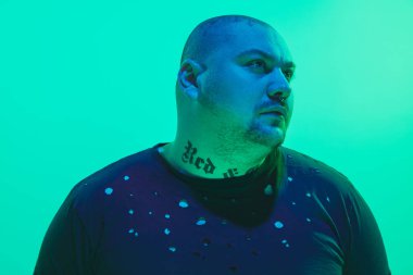 Portrait of a guy with colorful neon light on green background