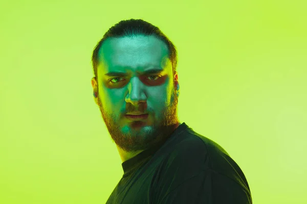 Portret van een man met kleurrijk neon licht op groene achtergrond - cyberpunk concept — Stockfoto