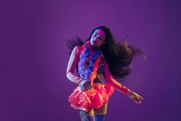 Привлекательная гавайская брюнетка модели на фиолетовом фоне студии в неоновом свете — стоковое фото