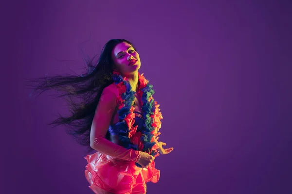 Attractive hawaiian brunette model on purple studio background in neon light — Stockfoto