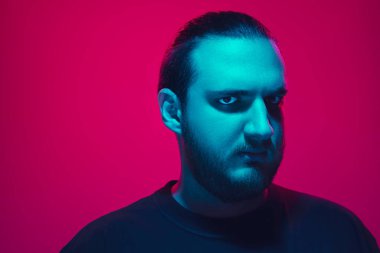 Portrait of a guy with colorful neon light on pink background - cyberpunk concept