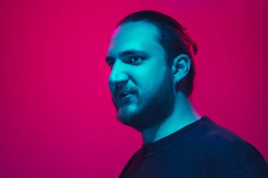 Portrait of a guy with colorful neon light on pink background - cyberpunk concept