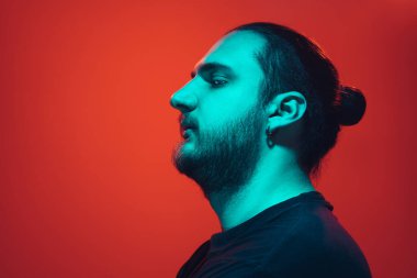 Portrait of a guy with colorful neon light on red background - cyberpunk concept