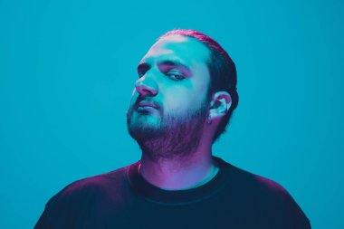Mavi arka planda renkli neon ışığı olan bir adamın portresi - siber punk konsepti