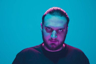 Mavi arka planda renkli neon ışığı olan bir adamın portresi - siber punk konsepti