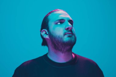 Mavi arka planda renkli neon ışığı olan bir adamın portresi - siber punk konsepti