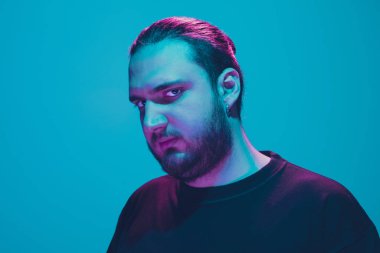 Mavi arka planda renkli neon ışığı olan bir adamın portresi - siber punk konsepti