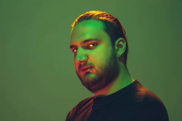 Портрет парня с ярким неоновым светом на зеленом фоне - концепция киберпанка — стоковое фото