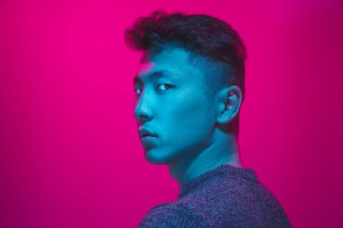 Portrait of a guy with colorful neon light on pink background - cyberpunk concept