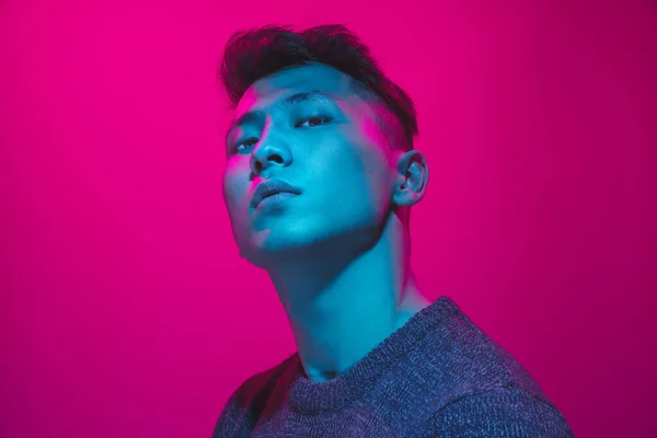 Portrait of a guy with colorful neon light on pink background - cyberpunk concept — Stockfoto