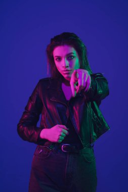 Beyaz kadın portresi mavi stüdyo arka planında neon ışıkta izole edilmiş.