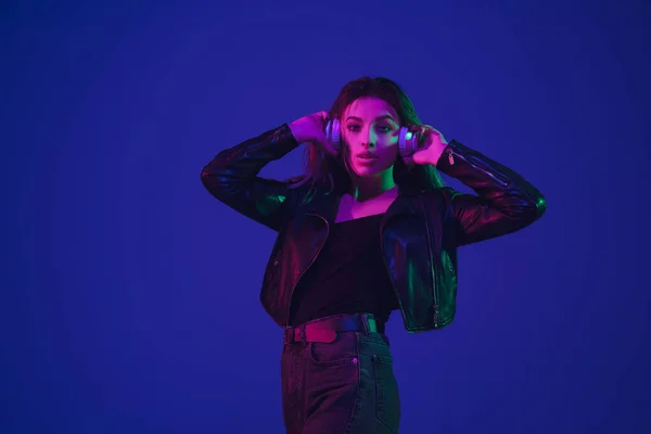 Mulheres caucasianas retrato isolado em fundo estúdio azul em luz de néon — Fotografia de Stock