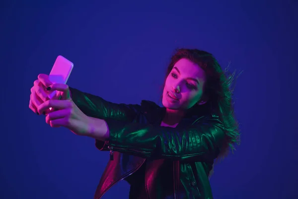 Blanke vrouwen portret geïsoleerd op blauwe studio achtergrond in neon licht — Stockfoto