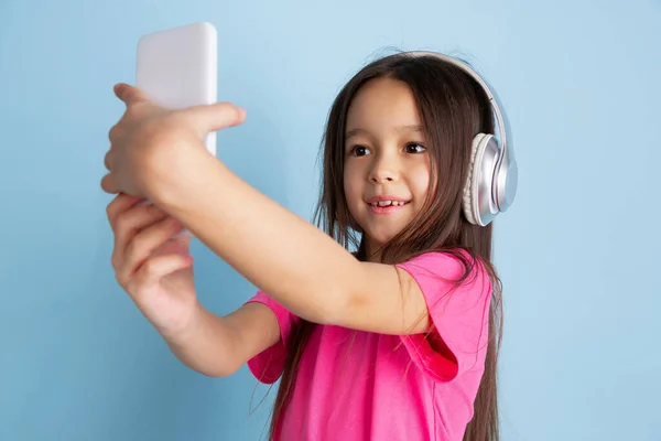 Caucasian little girls portrait on blue studio background — Stock Photo, Image