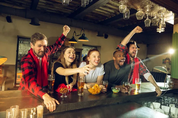 Los aficionados al deporte animando en el bar, pub y beber cerveza mientras que el campeonato, la competencia va —  Fotos de Stock