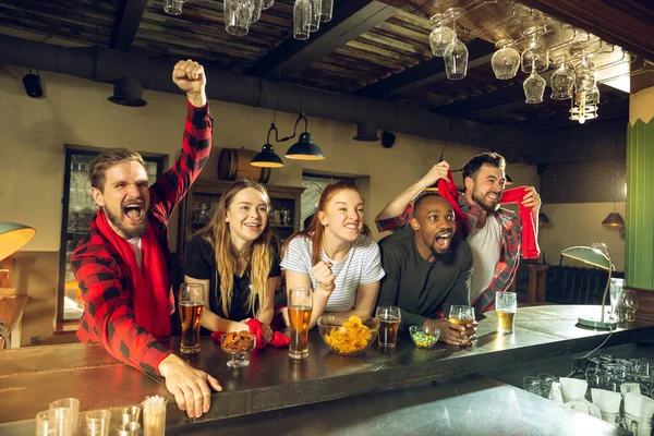 Sport fans juichen in de bar, pub en het drinken van bier, terwijl het kampioenschap, de concurrentie gaat — Stockfoto