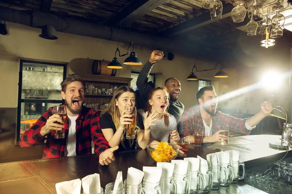 Sport fans juichen in de bar, pub en het drinken van bier, terwijl het kampioenschap, de concurrentie gaat — Stockfoto