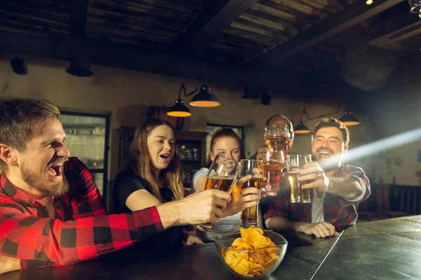 Fãs do esporte torcendo no bar, pub e bebendo cerveja enquanto campeonato, a competição está indo — Fotografia de Stock